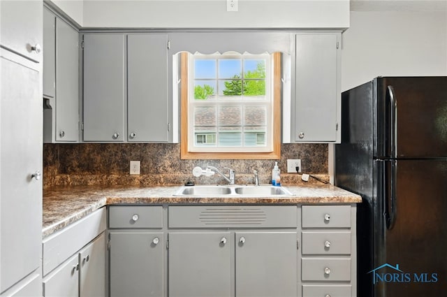 536 N Johnson St, Ada, OH 45810 - kitchen featuring freestanding refrigerator, a sink, gray cabinets, and decorative backsplash
