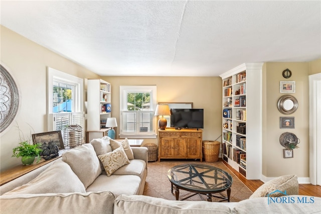 713 N Vine St, Fostoria, OH 44830 - living room featuring wood finished floors, a textured ceiling, and baseboards