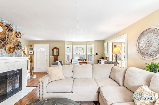 713 N Vine St, Fostoria, OH 44830 - living room with wood finished floors, a brick fireplace, and baseboards