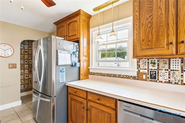 713 N Vine St, Fostoria, OH 44830 - kitchen featuring appliances with stainless steel finishes, brown cabinets, light tile patterned floors, light countertops, and baseboards
