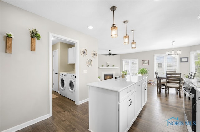 3130 Steeple Chase Ln, Perrysburg, OH 43551 - kitchen featuring washer and clothes dryer, ceiling fan, a warm lit fireplace, light countertops, and stainless steel range with electric cooktop