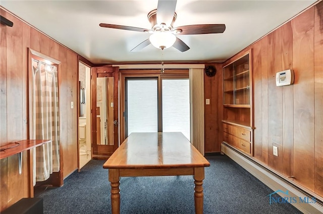 7149 Wales Rd, Northwood, OH 43619 - office area featuring wood walls, dark colored carpet, a ceiling fan, and a baseboard radiator