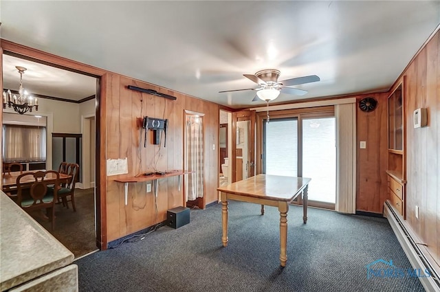 7149 Wales Rd, Northwood, OH 43619 - unfurnished dining area featuring a baseboard heating unit, a chandelier, wood walls, dark colored carpet, and a ceiling fan