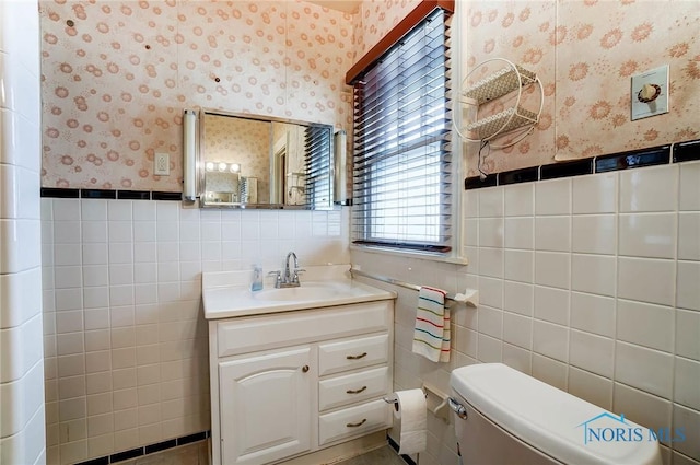 7149 Wales Rd, Northwood, OH 43619 - bathroom featuring wallpapered walls, tile walls, vanity, toilet, and a wainscoted wall