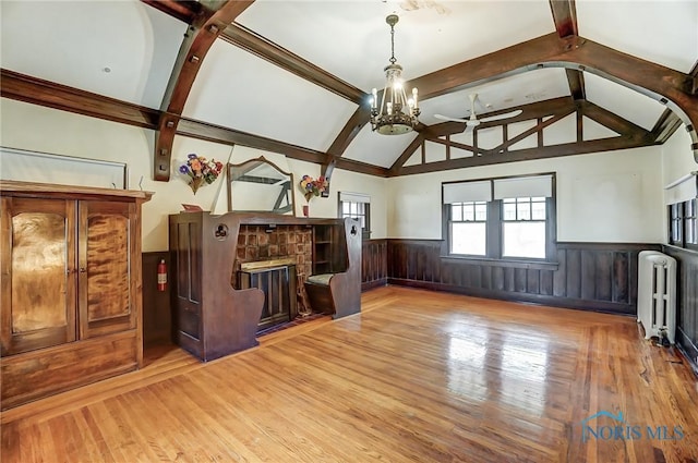 7149 Wales Rd, Northwood, OH 43619 - unfurnished living room featuring radiator heating unit, wainscoting, wood finished floors, and a chandelier