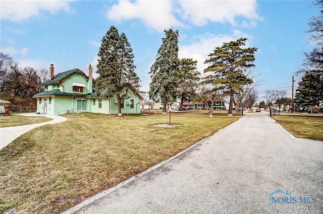 7149 Wales Rd, Northwood, OH 43619 - view of front of property featuring a chimney, a front yard, and stucco siding