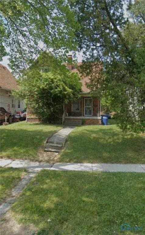 928 Islington St, Toledo, OH 43610 - obstructed view of property with a front lawn and a chimney