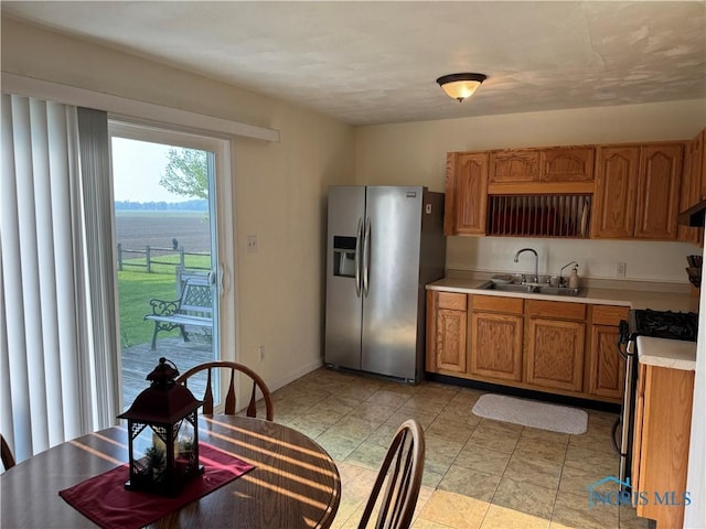V-437 State Route 108, Napoleon, OH 43545 - kitchen with stainless steel appliances, a sink, light countertops, brown cabinets, and baseboards