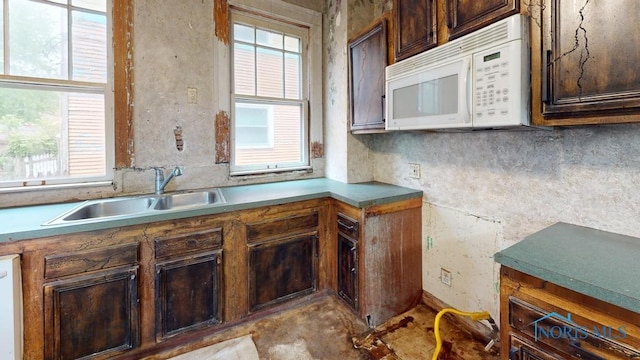 2720 Scottwood Ave, Toledo, OH 43610 - kitchen with white microwave, a sink, and dark brown cabinetry