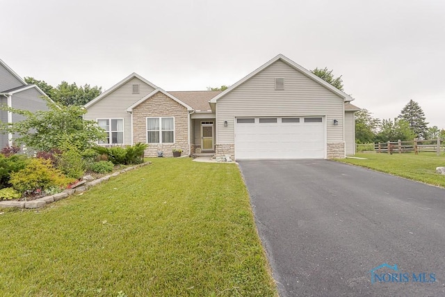 11023 Bay Trace Dr, Perrysburg, OH 43551 - ranch-style house with stone siding, a garage, and asphalt driveway