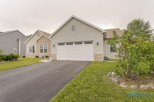 11023 Bay Trace Dr, Perrysburg, OH 43551 - view of front of home featuring stone siding, asphalt driveway, a garage, and a front lawn