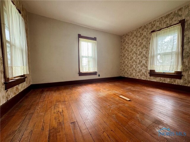 308 S Main St, Hicksville, OH 43526 - empty room featuring hardwood / wood-style floors and wallpapered walls