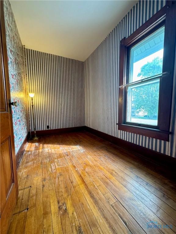308 S Main St, Hicksville, OH 43526 - spare room with wallpapered walls and hardwood / wood-style flooring