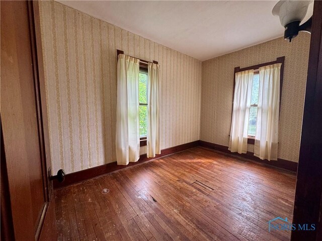 308 S Main St, Hicksville, OH 43526 - spare room featuring hardwood / wood-style flooring and wallpapered walls