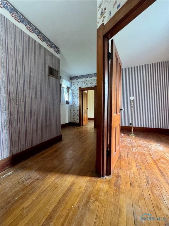 308 S Main St, Hicksville, OH 43526 - empty room featuring wallpapered walls and wood-type flooring