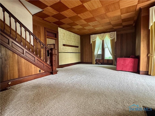 308 S Main St, Hicksville, OH 43526 - unfurnished living room with carpet, stairs, wooden walls, wood ceiling, and wallpapered walls