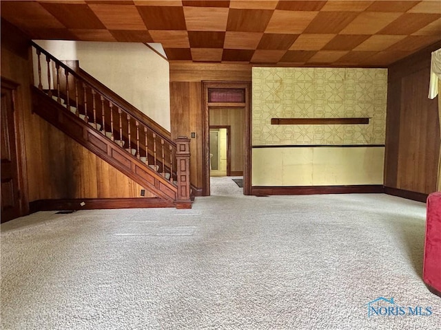 308 S Main St, Hicksville, OH 43526 - unfurnished living room with wood walls, stairs, and carpet floors