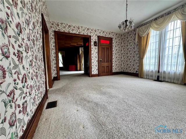 308 S Main St, Hicksville, OH 43526 - unfurnished dining area with wallpapered walls, carpet flooring, and a chandelier