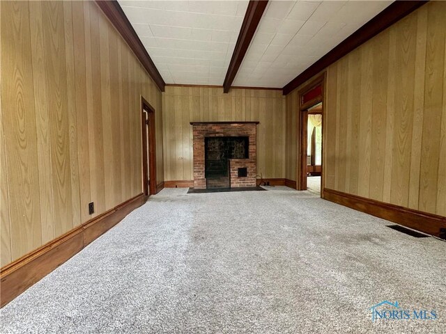 308 S Main St, Hicksville, OH 43526 - unfurnished living room featuring carpet flooring, a brick fireplace, crown molding, and wood walls