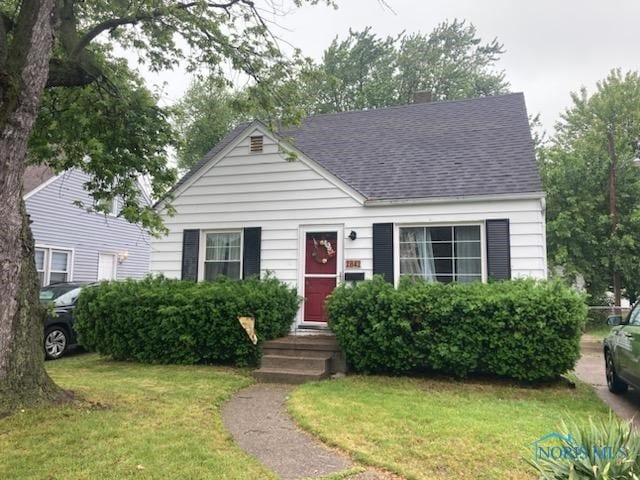 2842 Oak Grove Pl, Toledo, OH 43613 - view of front of house with a shingled roof, a front yard, and a chimney
