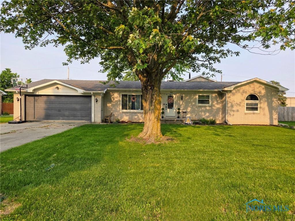 808 W St, Archbold, OH 43502 - ranch-style house featuring an attached garage, concrete driveway, and brick siding