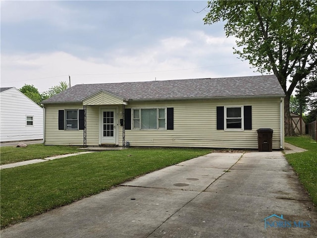 711 Circle Dr, Fostoria, OH 44830 - single story home with a front lawn, concrete driveway, and a shingled roof