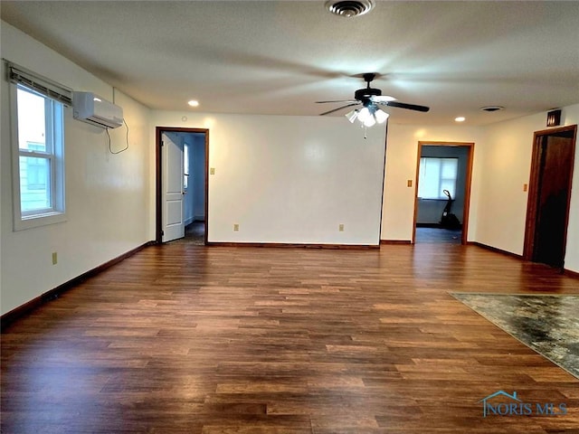 711 Circle Dr, Fostoria, OH 44830 - empty room featuring an AC wall unit, ceiling fan, dark wood-style flooring, and recessed lighting