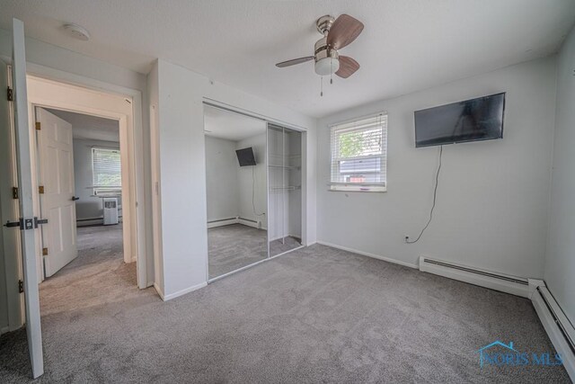 3849 Sylvanwood Dr, Sylvania, OH 43560 - unfurnished bedroom featuring carpet, a baseboard heating unit, a closet, baseboards, and a ceiling fan