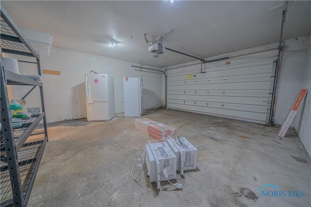 3849 Sylvanwood Dr, Sylvania, OH 43560 - garage featuring freestanding refrigerator and a garage door opener