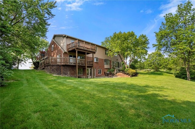 16890 W River Rd, Bowling Green, OH 43402 - back of property featuring a lawn, a deck, and brick siding