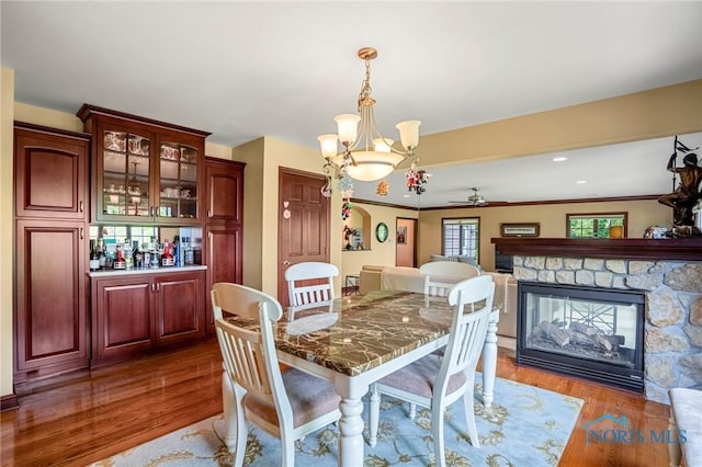16890 W River Rd, Bowling Green, OH 43402 - dining room featuring a fireplace, a ceiling fan, wood finished floors, and a chandelier