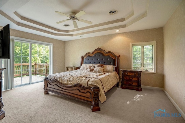 16890 W River Rd, Bowling Green, OH 43402 - bedroom with a tray ceiling, access to exterior, carpet flooring, and multiple windows