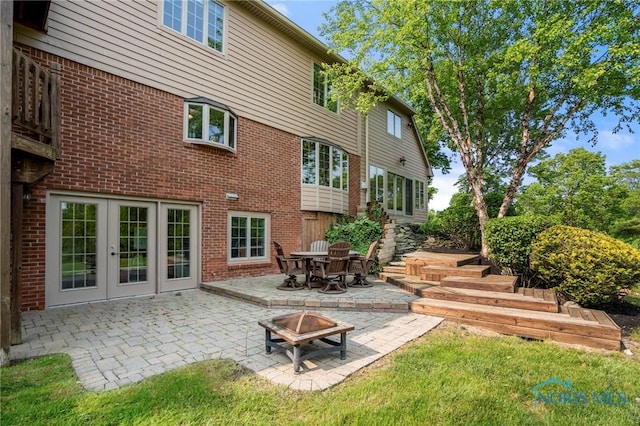 16890 W River Rd, Bowling Green, OH 43402 - rear view of property featuring a fire pit, a patio area, brick siding, and a lawn