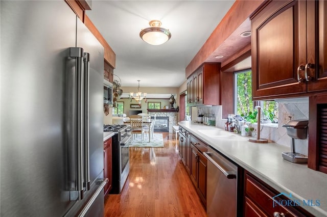 16890 W River Rd, Bowling Green, OH 43402 - kitchen with stainless steel appliances, light countertops, wood finished floors, a chandelier, and pendant lighting