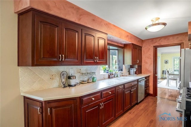 16890 W River Rd, Bowling Green, OH 43402 - kitchen featuring stainless steel appliances, light wood-style floors, a sink, backsplash, and light countertops
