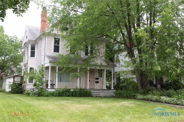 2110 Robinwood Ave, Toledo, OH 43620 - view of front of home featuring a porch, a front yard, and a chimney