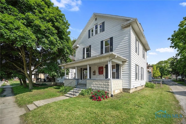 230 W S St, Fostoria, OH 44830 - american foursquare style home with a porch and a front yard
