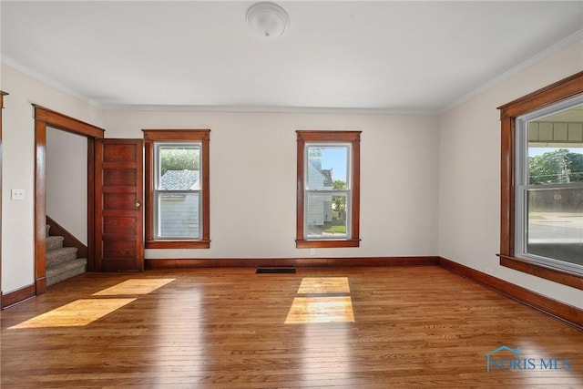 230 W S St, Fostoria, OH 44830 - unfurnished room with healthy amount of natural light, wood finished floors, ornamental molding, and stairway