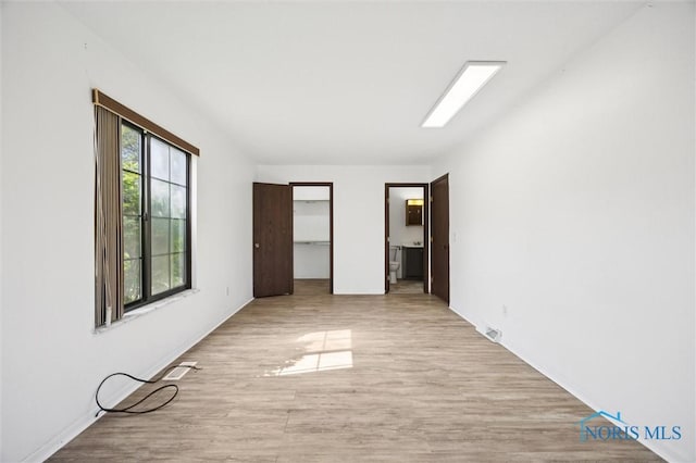 4519 W Bancroft St Unit 4, Toledo, OH 43615 - unfurnished bedroom featuring wood finished floors, a walk in closet, and ensuite bath