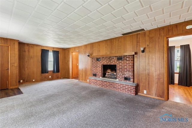 308 Edith Ave, Findlay, OH 45840 - unfurnished living room with wood walls, a fireplace, and carpet flooring