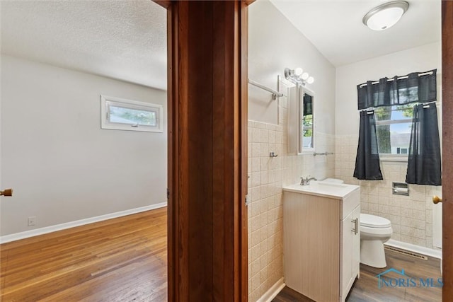 308 Edith Ave, Findlay, OH 45840 - bathroom with vanity, tile walls, toilet, wood finished floors, and wainscoting