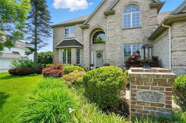 7433 Valhalla Dr, Maumee, OH 43537 - view of exterior entry featuring brick siding and a lawn
