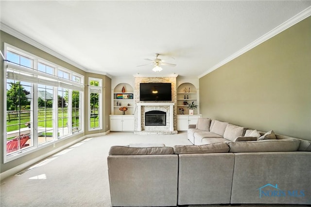 7433 Valhalla Dr, Maumee, OH 43537 - living room featuring ornamental molding, a ceiling fan, a glass covered fireplace, built in shelves, and carpet