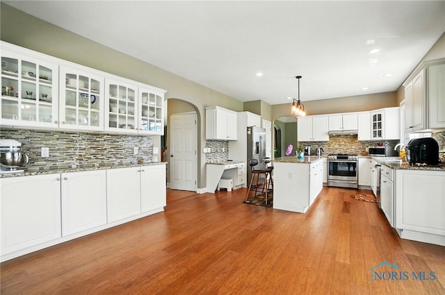 7433 Valhalla Dr, Maumee, OH 43537 - kitchen with appliances with stainless steel finishes, tasteful backsplash, arched walkways, a center island, and white cabinets