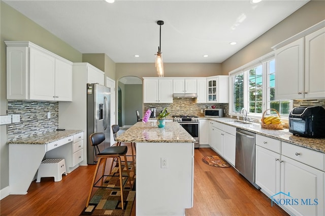 7433 Valhalla Dr, Maumee, OH 43537 - kitchen with stainless steel appliances, under cabinet range hood, backsplash, wood finished floors, and recessed lighting