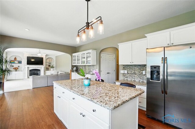 7433 Valhalla Dr, Maumee, OH 43537 - kitchen featuring stainless steel fridge, arched walkways, a kitchen island, and decorative backsplash