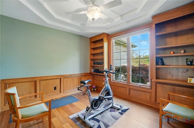 7433 Valhalla Dr, Maumee, OH 43537 - workout room featuring a tray ceiling, built in shelves, light wood finished floors, a ceiling fan, and wainscoting