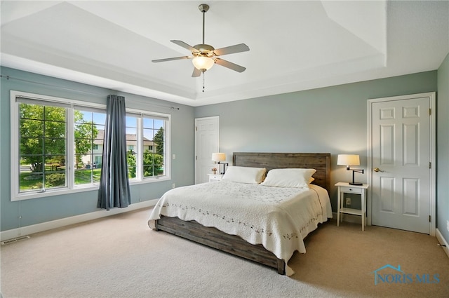 7433 Valhalla Dr, Maumee, OH 43537 - carpeted bedroom with a tray ceiling, baseboards, and a ceiling fan