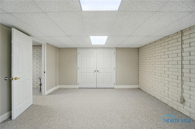 7433 Valhalla Dr, Maumee, OH 43537 - finished basement featuring a paneled ceiling, brick wall, carpet flooring, and baseboards