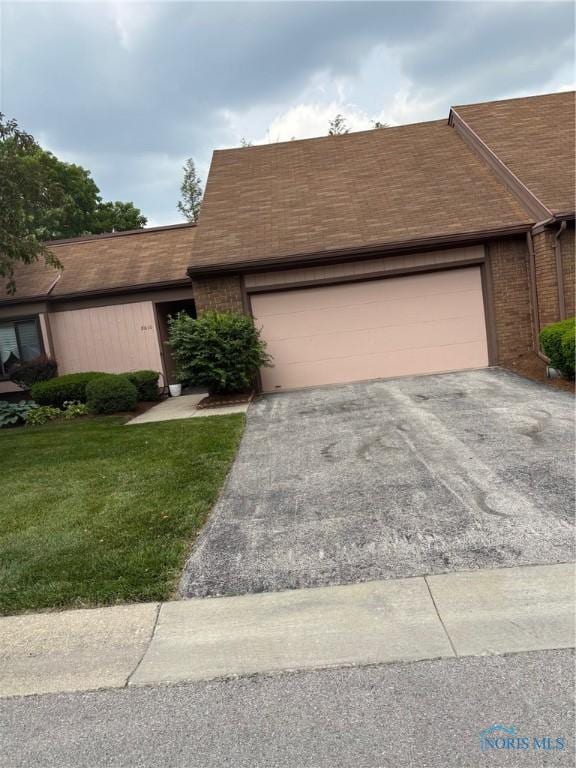 5610 Hogans Unit 18, Toledo, OH 43615 - view of front of house with driveway, a garage, a front lawn, a shingled roof, and brick siding